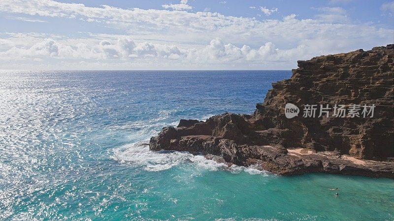 人们在热带海滩碧绿的海水中游泳。Halona海滩湾。太平洋的蓝色海浪打败了瓦胡岛火山悬崖。晴朗的一天。DCI 4 k